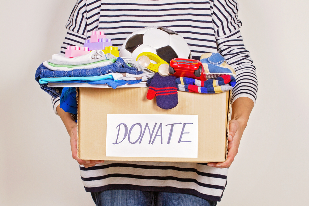 lady holding a donation box full of stuff