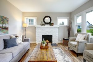 Traditional living room with white brick fireplace, symmetrical furniture layout and wood finishes. 