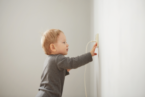 Baby playing with wall socket.