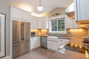 White square kitchen with new stainless steel appliances.