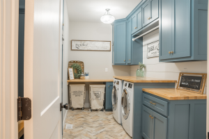 Laundry room in custom home with blue cabinets.