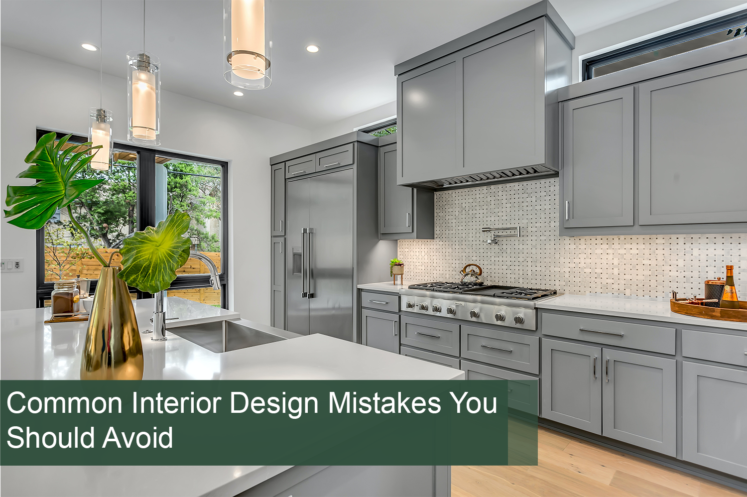 A kitchen with gray cabinets and pendant lights over the island - interior design mistakes have been avoided here.