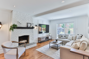 A living room with white walls and furniture with a white fireplace as the focal point of the room.