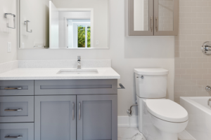 A white bathroom with a gray vanity in a custom built home.